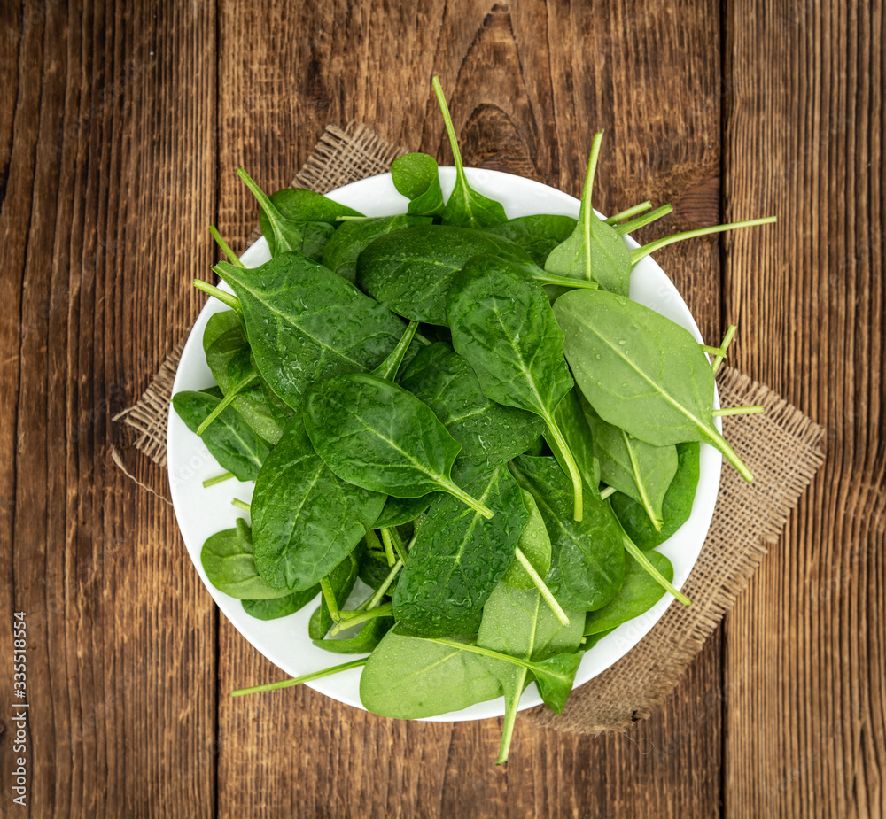 Old wooden table with fresh Spinach (selective focus; close-up shot) Old wooden table with fresh Spinach (selective focus; close-up shot)