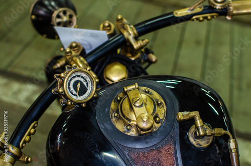 WROCLAW, POLAND - August 11, 2019: USA cars show:  Close up of the tank and speedometer of a vintage motorcycle of shiny black and gold color.
