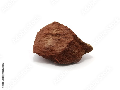 Red shale specimen on white background. Shale is a fine-grained, clastic sedimentary rock.