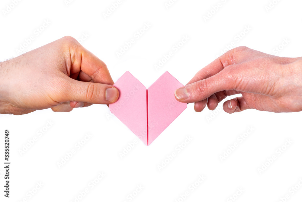 Man and Woman hold a heart made out of paper on white background Man and Woman hold a heart made out of paper on white background