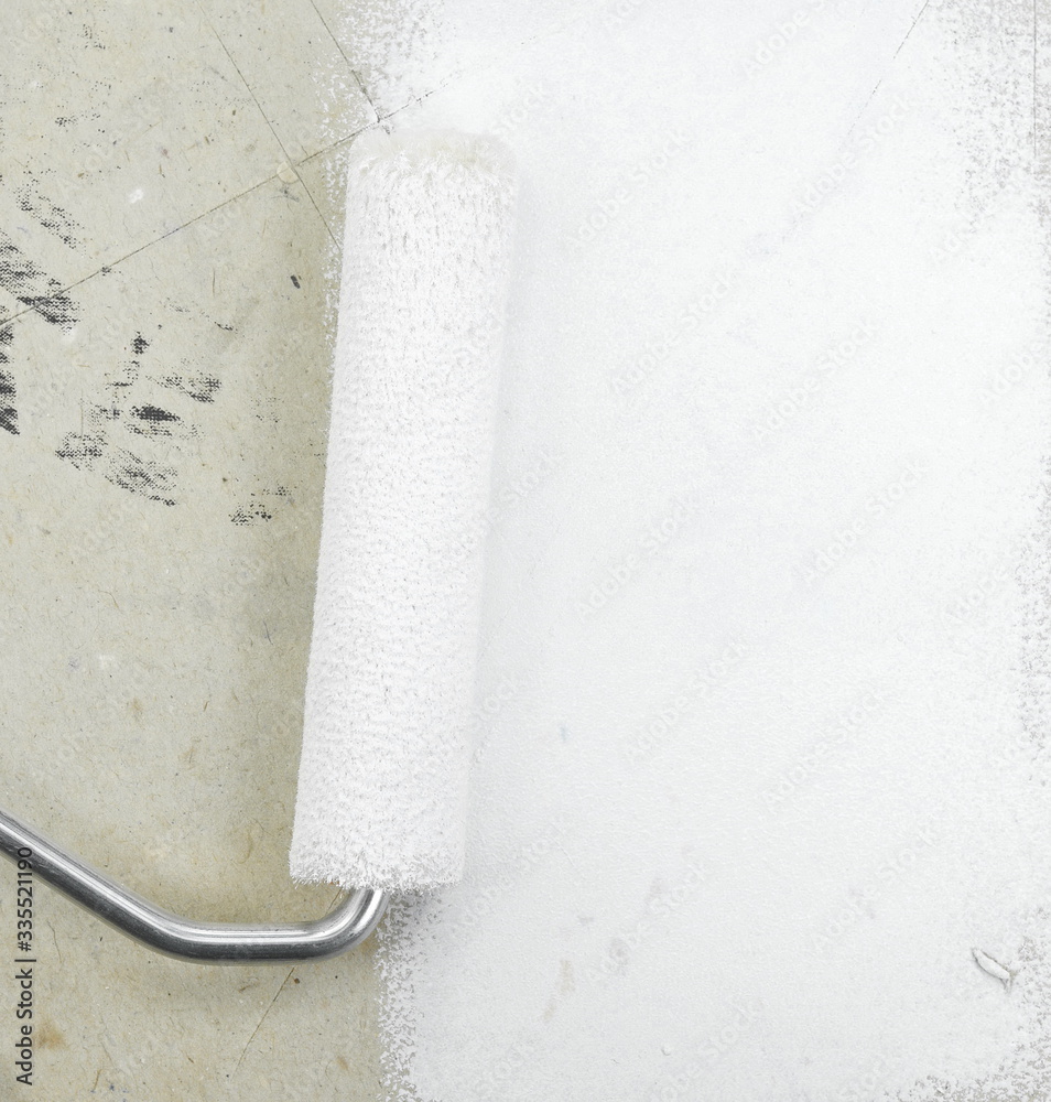 Obraz premium Painting a rough wall with roller. Paint roller leaving stroke of white color over a rustic background. usable for text and messages.