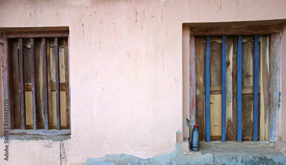two closed old wooden windows at a rural village in India.