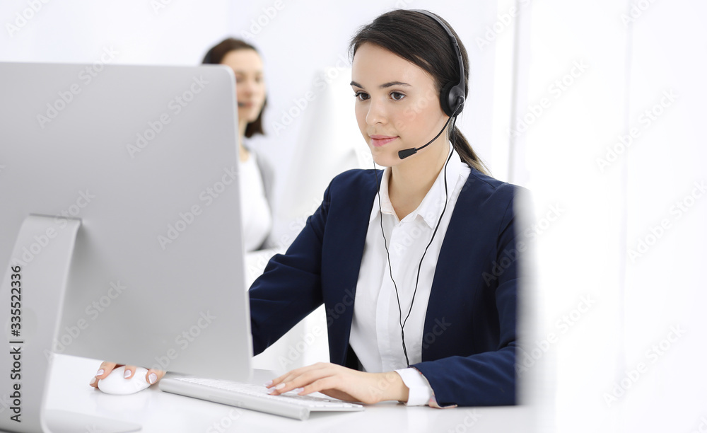 Call center. Beautiful woman sitting and working in headset at customer service office. Business concept Call center. Beautiful woman sitting and working in headset at customer service office. Business concept