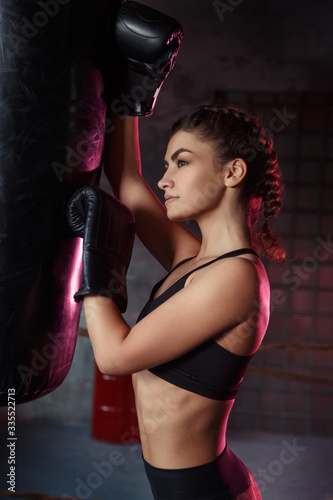 Beautiful slim sexy sportswoman in the ring and the gym in boxing gloves. © ksi