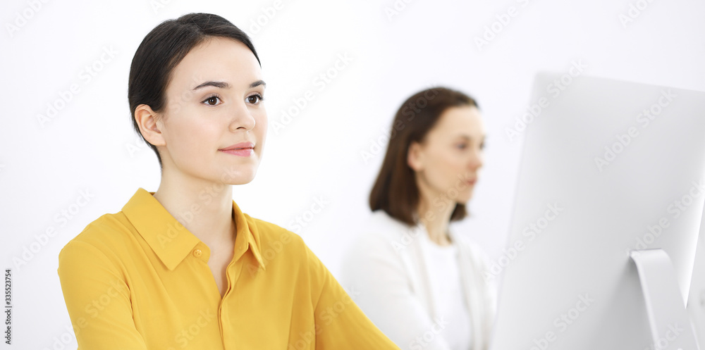 Businesswoman in mustard colored blouse looking at camera at office, headshot Businesswoman in mustard colored blouse looking at camera at office, headshot