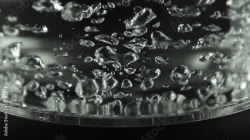 In a kettle with transparent glass walls, water boils. Stainless bottom. photo