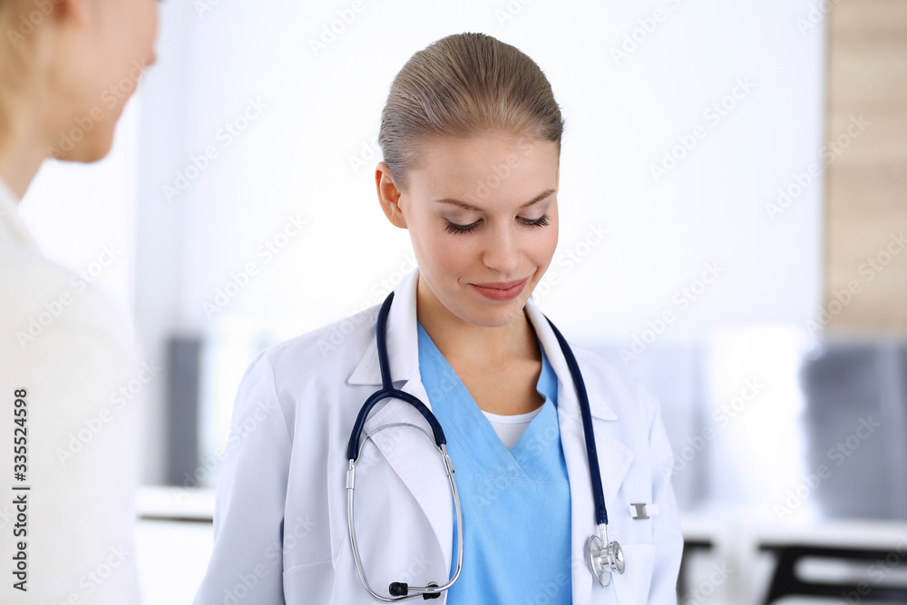 Doctor and patient during consultation. Physician at work filling up medication history record while sitting in emergency hospital, portrait shoot. Medicine and health care concept Doctor and patient during consultation. Physician at work filling up medication history record while sitting in emergency hospital, portrait shoot. Medicine and health care concept