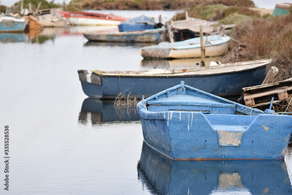 A small old blue boat abandoned