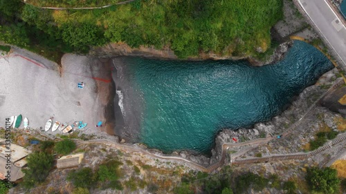 Aerial top down view of Fiordo di furore beach. Incredible beauty panorama of a paradise. The rocky seashore of southern Italy. Sunny summer day. Car ride on stone bridge and clear water. Amalfi coast