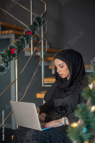 Beautiful two girls with hijab hanging out, typing on laptop, learining about photography and study photo