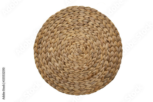 Round woven straw mat isolated against white background