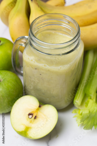 close-up of celery and fresh apples and banana smoothie
