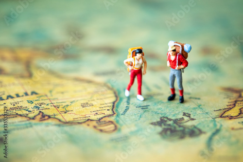 Photography Miniature people: Group of backpacker on vintage world map using as business trip traveler adviser agency or explorer on earth background concept