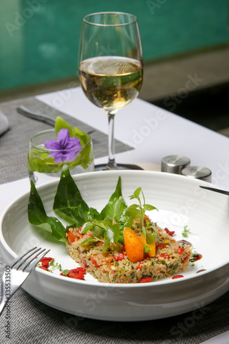 Quinoa salad served vith various vegetables. Healthy and delicious vegetarian meal. Exquisite dish. Creative restaurant meal concept.