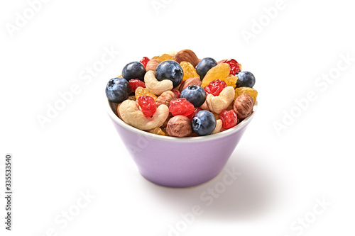 Nuts and dried fruit berries mix in bowl. Fitness diet super food. Energy cereal healthy meal. Muesli, blueberry, seeds, hazelnut, almond, oatmeal isolated on white, closeup.