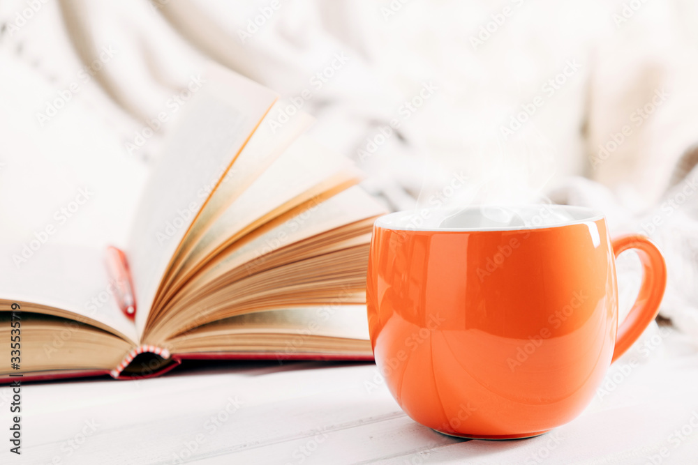 Autumn cozy composition. Book, steaming cup of hot chocolate. Autumn or winter concept of coziness and interior. Front view, copy space Autumn cozy composition. Book, steaming cup of hot chocolate. Autumn or winter concept of coziness and interior. Front view, copy space