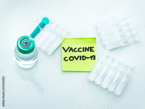 Covid-19 vaccine research. vial with syringe, Ampoules and note.