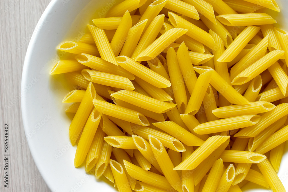 Yellow macaroni (pasta) in a white plate on the table Yellow macaroni (pasta) in a white plate on the table