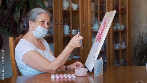 Senior woman painting at home during self isolation quarantine coronavirus