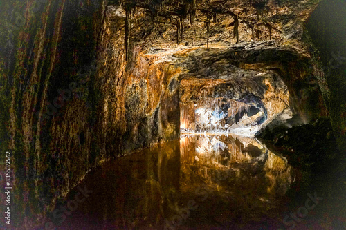 Urlaub in Deutschland: Saalfelder Feengrotten - Spiegelung von Tropfsteinhöhle mit Lichteffekten in glatter Wasseroberfläche