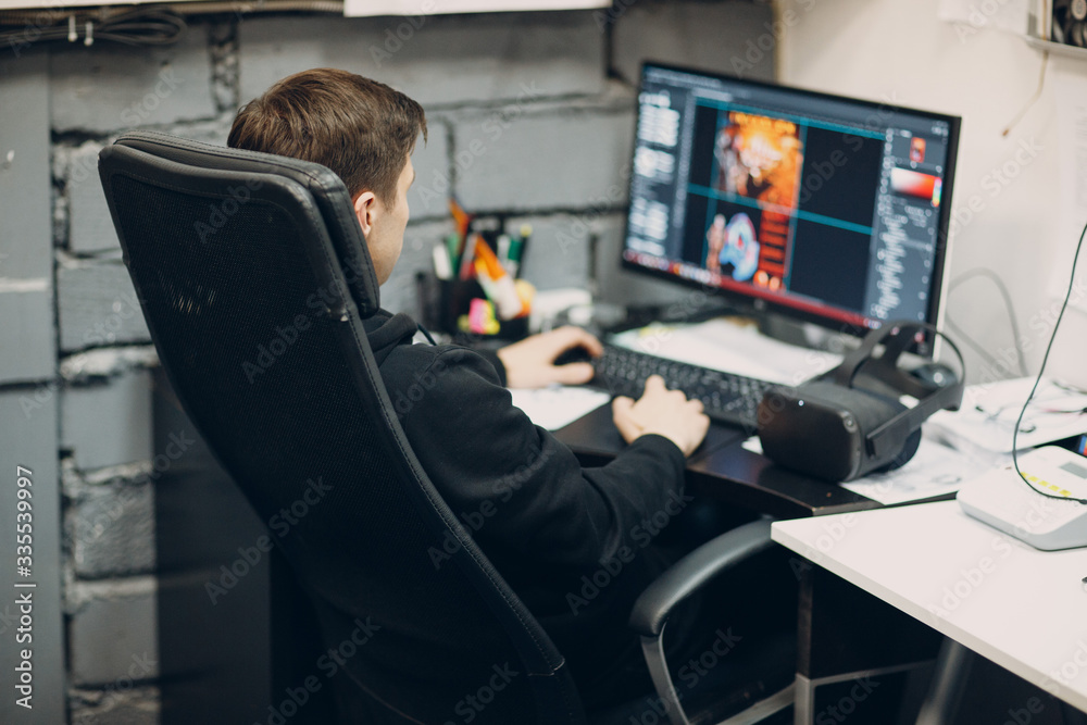 Stay home. Programmist with virtual reality headset, VR glasses with joystick with personal computer.