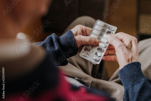 Old man holding medicine blister in hands