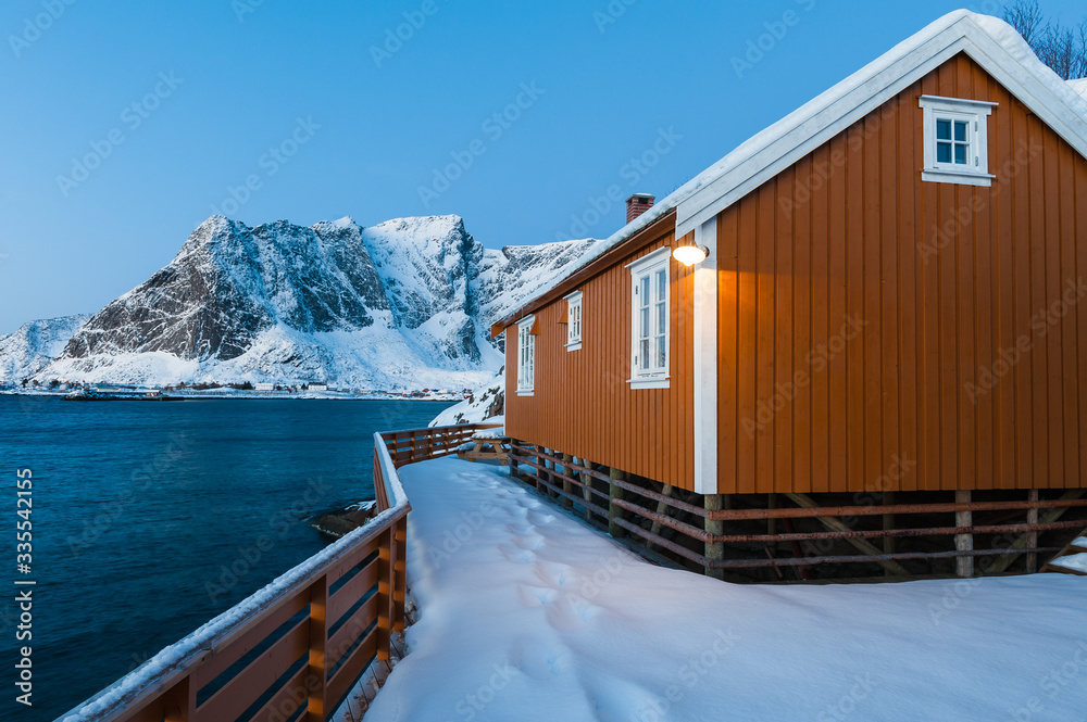 Yellow house in front of snow covered mountains, Norway