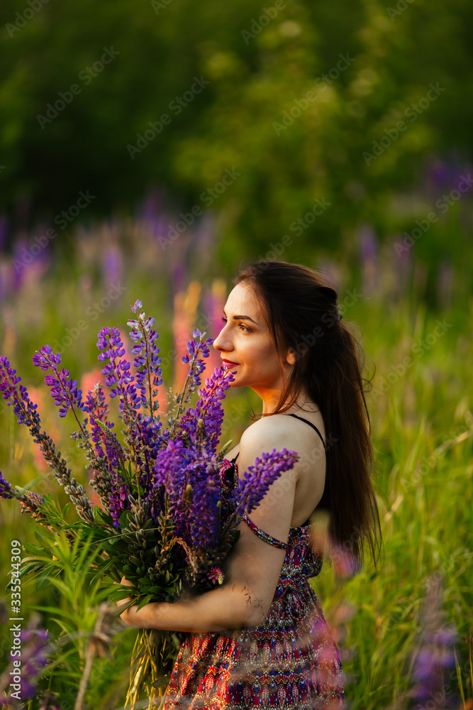 Young girl stand in field overlooking lavender field. Smiling carefree caucasian girl in dress enjoying the sunset Young girl stand in field overlooking lavender field. Smiling carefree caucasian girl in dress enjoying the sunset