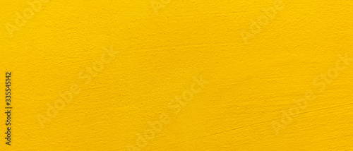 Blurred Yellow stucco wall background. Yellow painted cement wall texture.