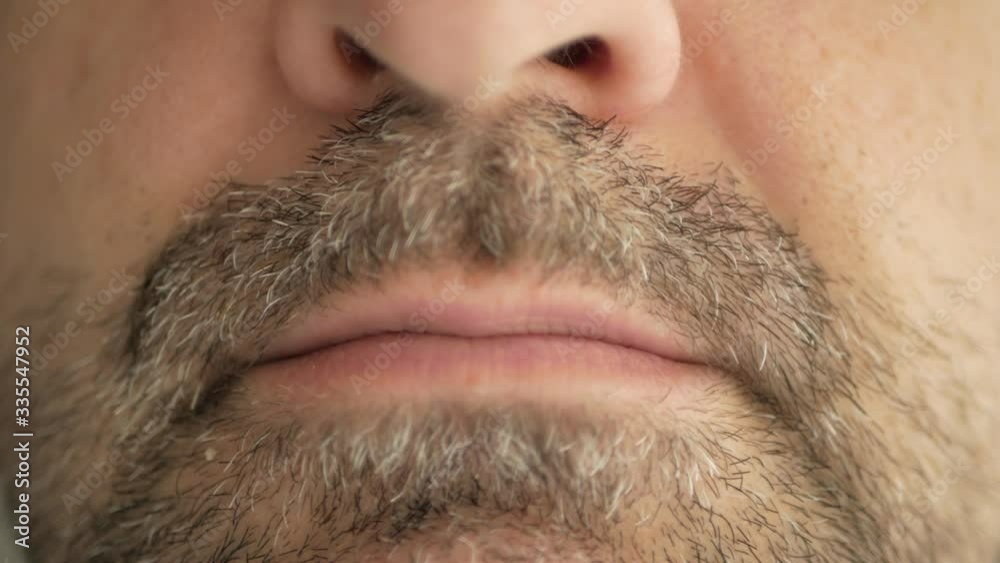 A man with a beard swallows a pill from the virus, coronavirus and makes a wry face. Super macro close-up. A man with a beard swallows a pill from the virus, coronavirus and makes a wry face. Super macro close-up.