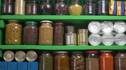 Stocked home pantry ready for coronavirus quarantine and self-isolation. Long storage foods, drinks, supplies. Dry beans, rice, pasta, popcorn, butter, nuts, seeds, canned goods and vegetables