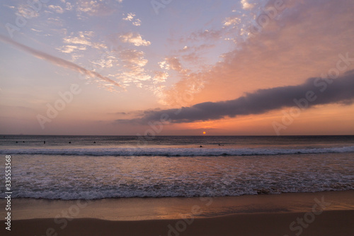 sunset on the beach  sky with orange colors and clouds  sea with small waves