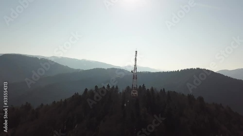 Communication tower during morning sunrise with clouds and fog. Mobile tower on the mountain. 4G and 5G communication