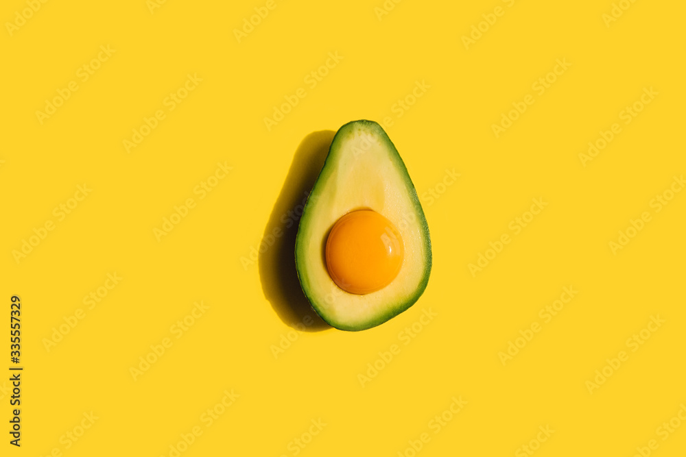 yolk in avocado and eggs on a yellow background