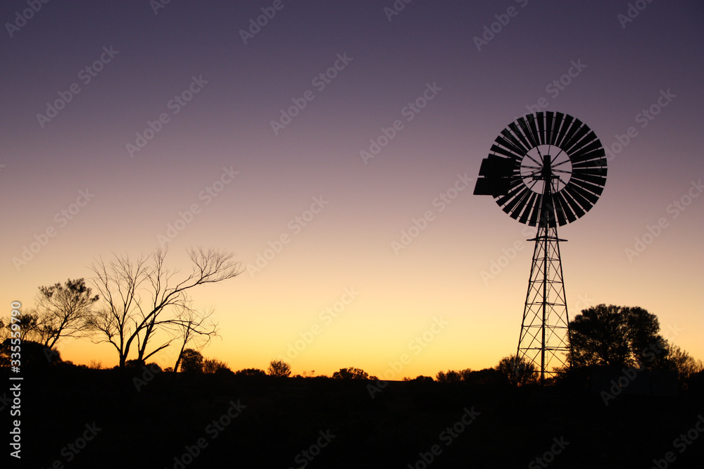 Sunset in Australian desert with windmill silhouette 