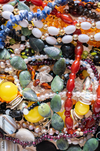 A lot of natural stone jewelry  quartz  rock crystal  amber  pearls  opal  carnelian  garnet  sodalite  agate-texture  background  luxury  fashion concept  vertical