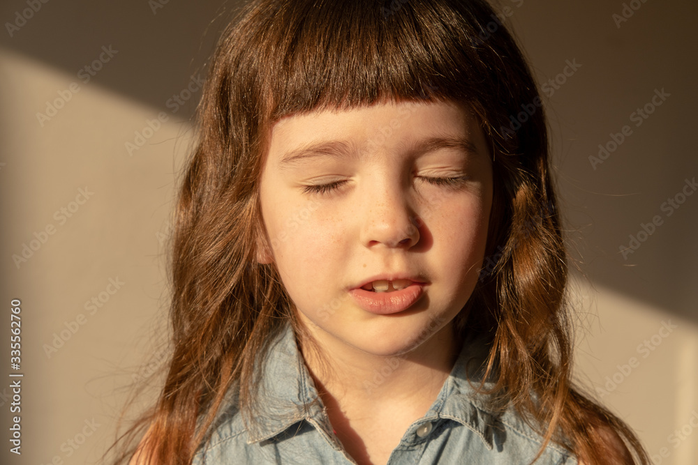 A girl with freckles on her face turns her face to the sun. A girl with freckles on her face turns her face to the sun.