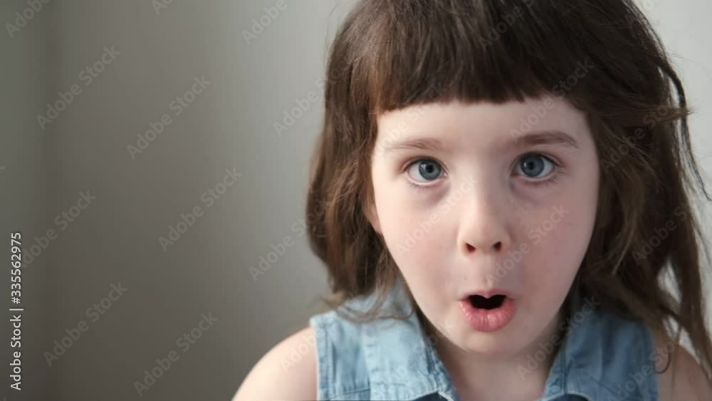 A 6-7 year old girl makes faces and makes faces. Close up. A 6-7 year old girl makes faces and makes faces. Close up.