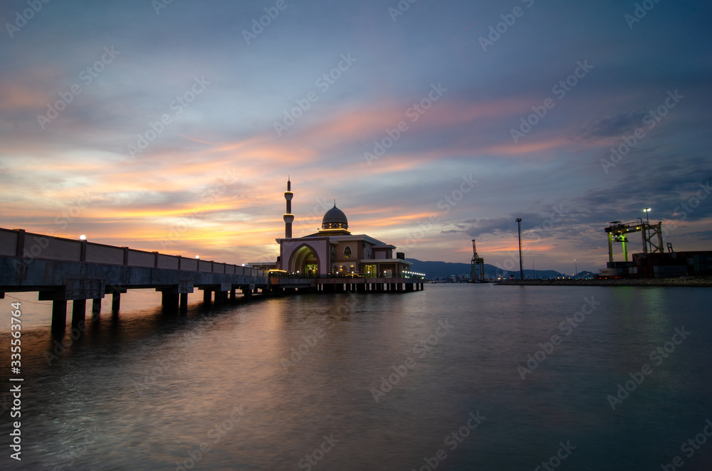Butterworth, Malaysia floating mosque with dramatic sunset cloud with container terminal as background.