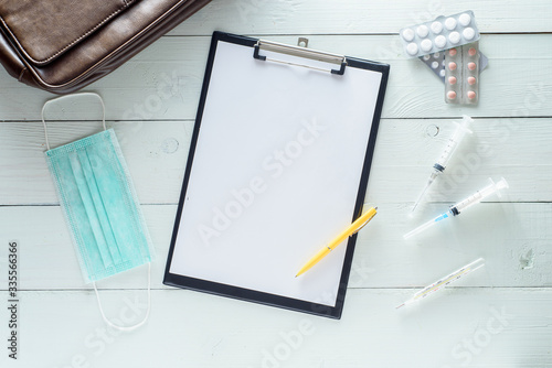 Notebook for notes, medicines, syringes. Shot on a white wooden background from above.