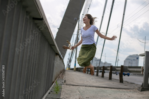 Wallpaper Mural horizontal photo of a slender girl in a white t-shirt and green skirt on the background of the bridge Torontodigital.ca