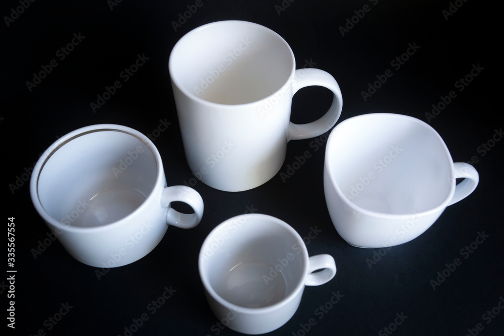 Large, medium, small cups for coffee against a dark background. Large, medium, small cups for coffee against a dark background.
