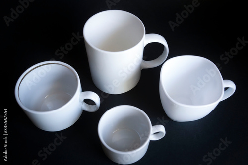 Large, medium, small cups for coffee against a dark background.