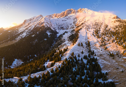 Aerial view of the Presolana covered in snow and the Cassinelli refuge during a winter sunset, Val Seriana, Bergamo district, Lombardy, Italy. photo