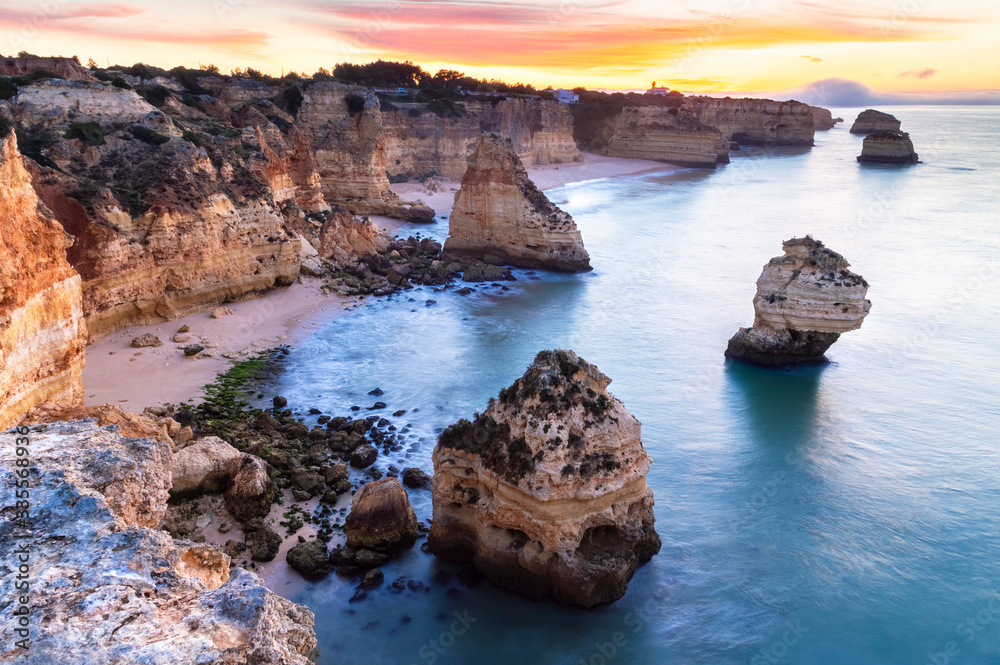 A colorful sunrise at the beach of Praia da Marinha, Caramujeira, Lagoa, Algarve, Portugal, Europe. A colorful sunrise at the beach of Praia da Marinha, Caramujeira, Lagoa, Algarve, Portugal, Europe.