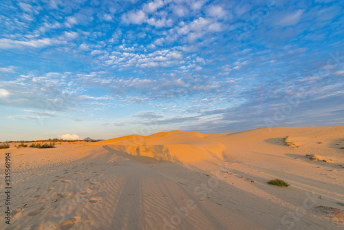 Great sand dune under blue sky and beautiful textured clouds 