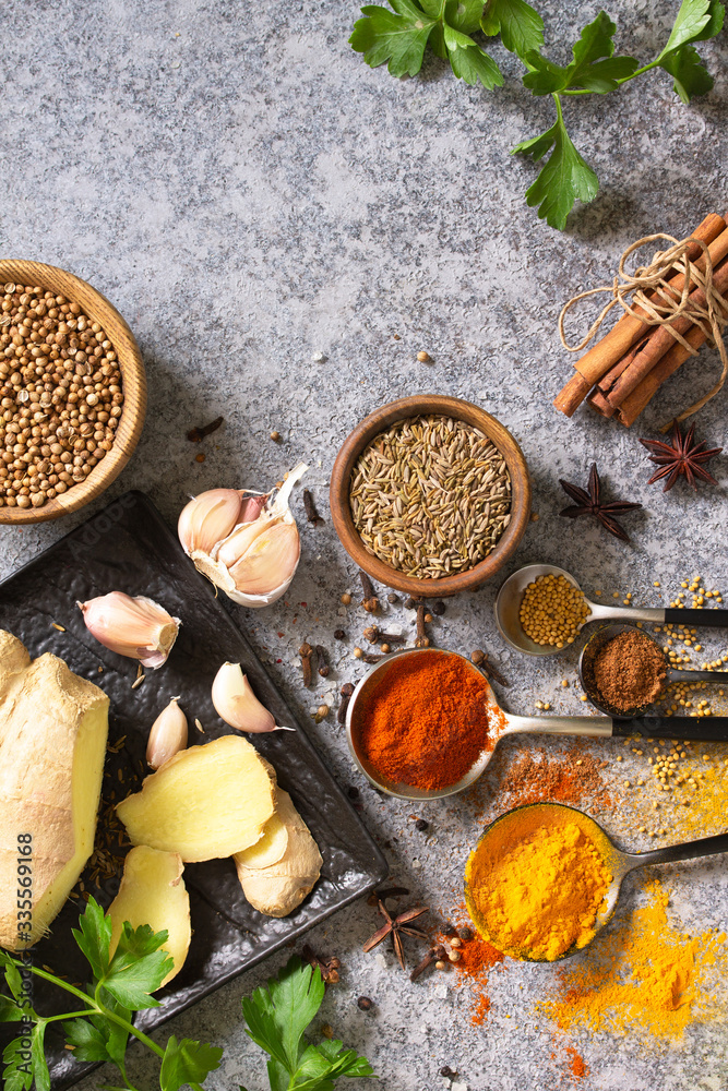 Set of Indian spices and herbs selection on a stone table. Top view flat lay background. Copy space.