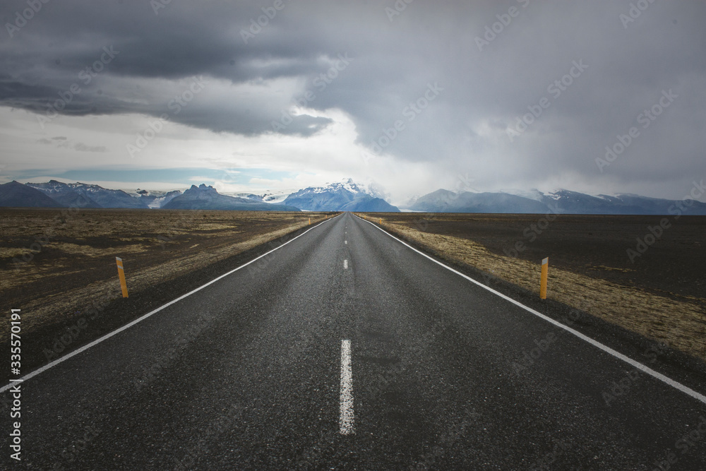 Infinite straight road in Iceland going to a glacier