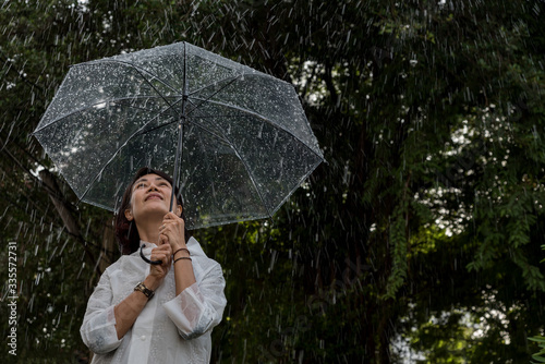 Obraz na płótnie In raining day woman open umbrella stand in garden feel happyand have warmth,romantic feeling. w salonie