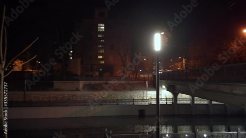 City river embankment and bridge lit by lanterns at night in autumn, Salgir River Embankment in Simferopol. photo